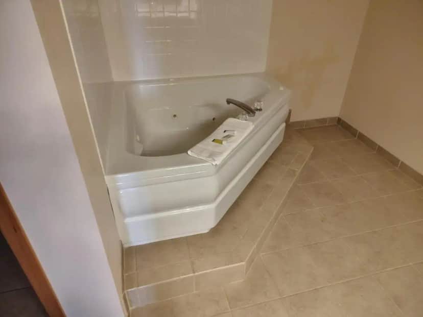 a bathroom with a bath tub with a sink at Western Executive Inn in Billings