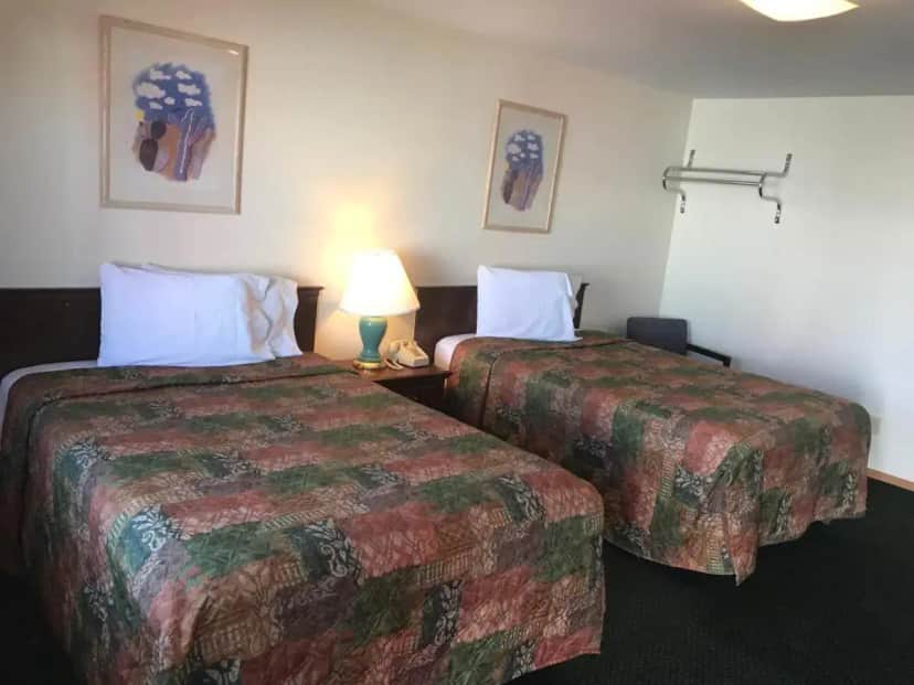 a hotel room with two beds and a lamp at Western Holiday Motel in Wichita