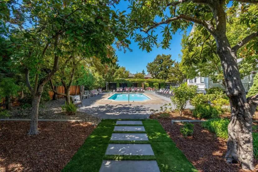 a pool in a yard with trees and grass at White House Napa in Napa