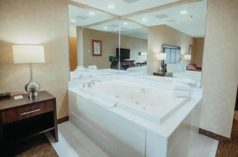a large bathroom with a large tub with a large mirror at Wildwood Lodge in Pewaukee