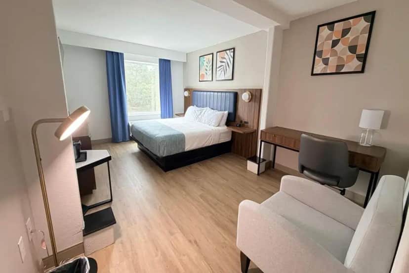 a small hotel room with a bed and a couch at Wingate by Wyndham Athens GA in Athens