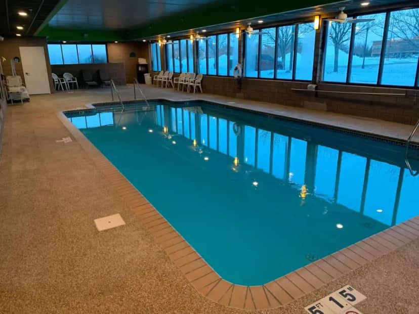 a large pool with blue water in a building at Wingate by Wyndham Fargo in Fargo