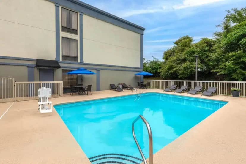 a swimming pool in front of a building at Wingate by Wyndham Greensboro-Coliseum in Greensboro