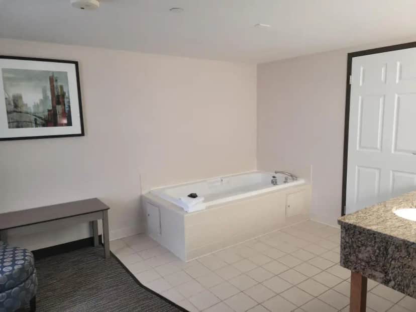 a white bathroom with a tub and a sink at Wingate by Wyndham Lima in Lima
