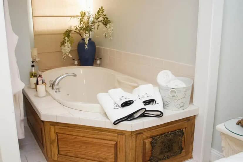 a bathroom with a tub and a sink with towels at Woodstock Inn Bed & Breakfast in Independence