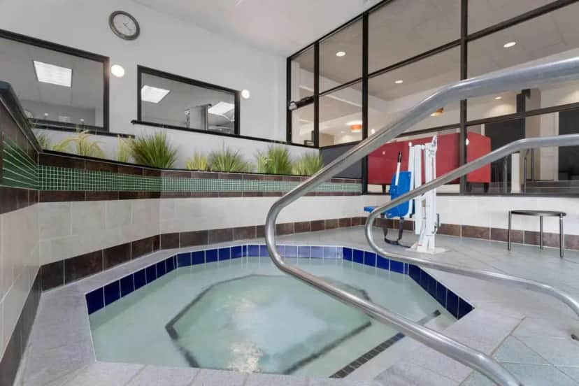 a swimming pool with a hot tub in a building at Wyndham Minneapolis South Burnsville in Burnsville