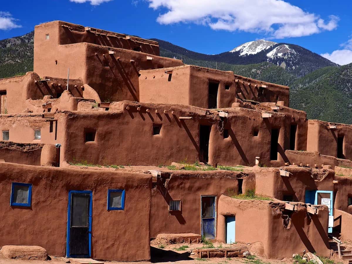 Adobe buildings of Taos Pueblo with the Sangre de Cristo Mountains behind