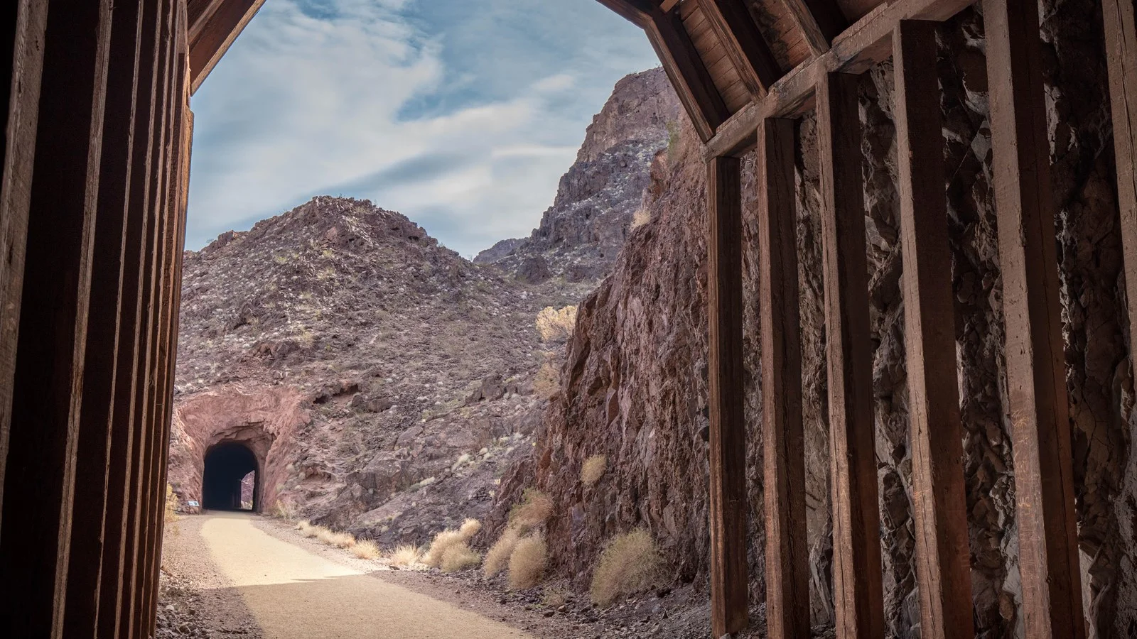 View from a timber-lined tunnel toward another tunnel on Lake Mead's Historic Railroad Trail