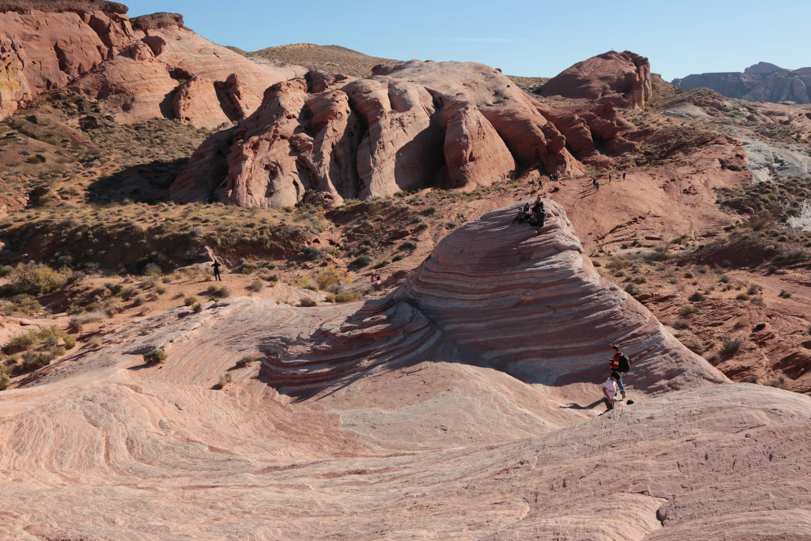 Striped sandstone at the Fire Wave in Valley of Fire State Park, with hikers on the rock