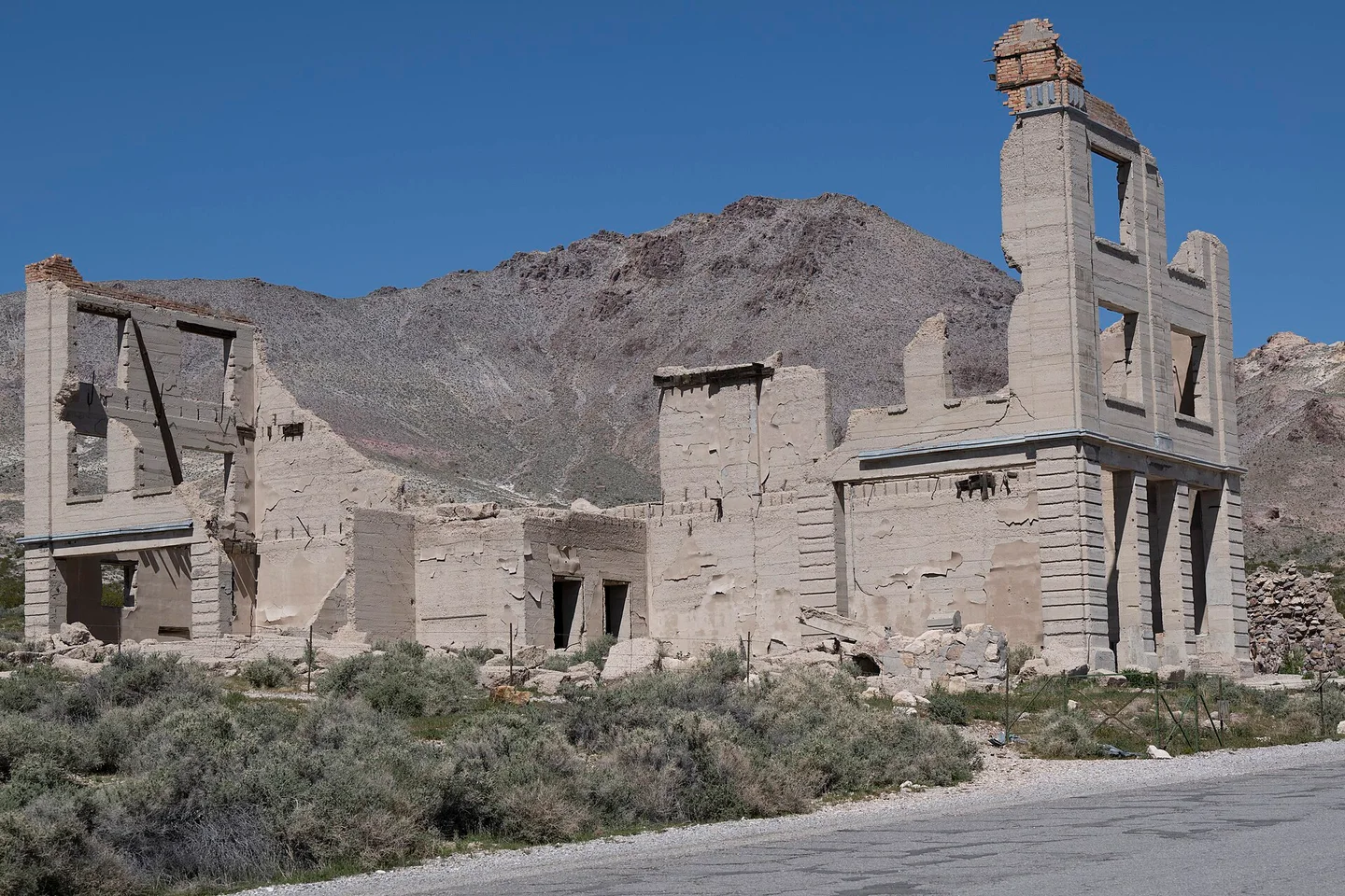 Standing walls and empty windows of the Cook Bank building at Rhyolite, Nevada, photographed in 2024