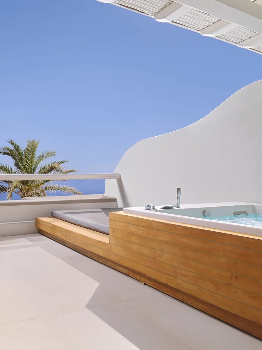 A suite terrace with a private jacuzzi under a pergola
